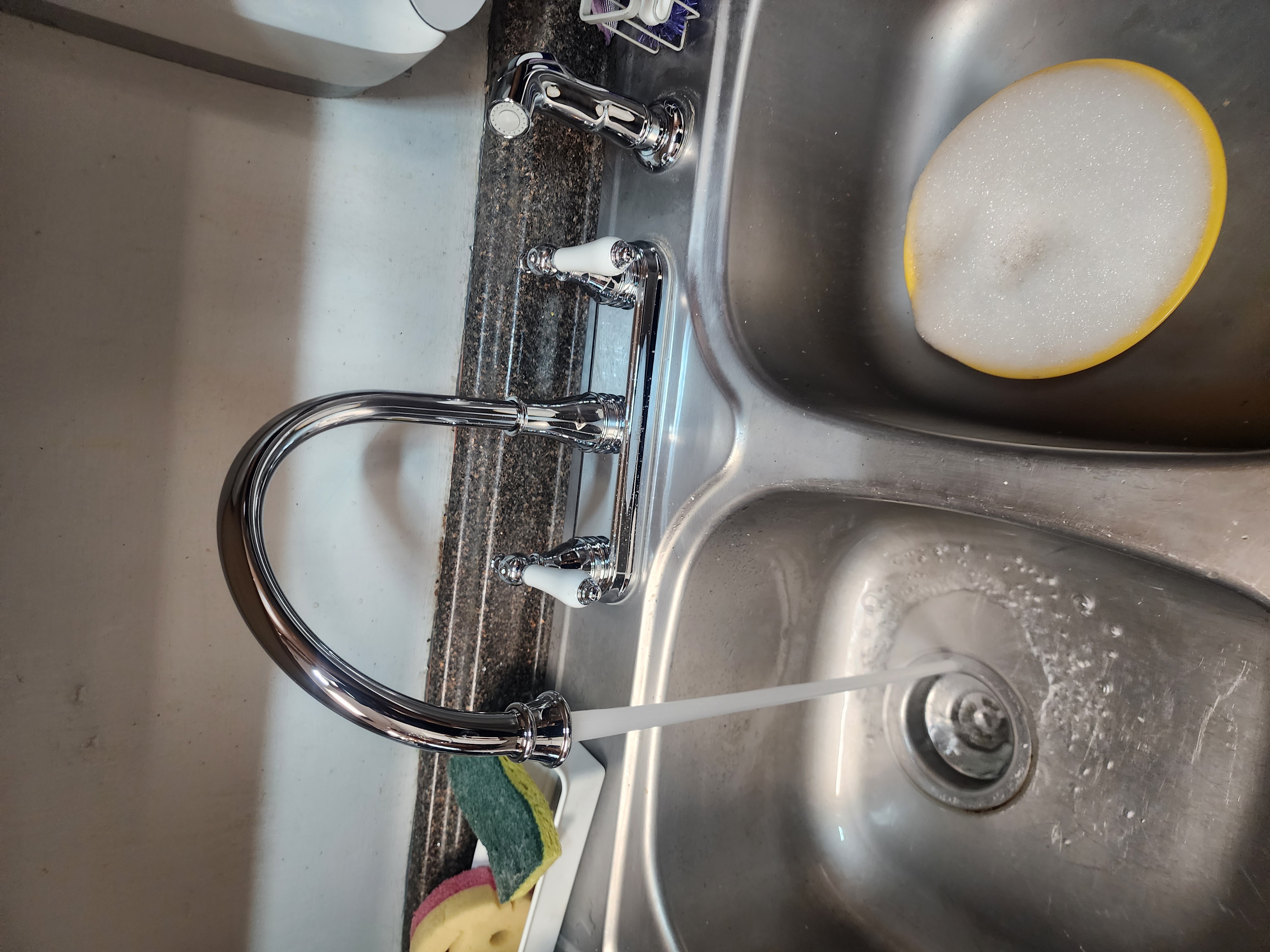 Newly installed chrome kitchen faucet running water in Pittsburgh PA home