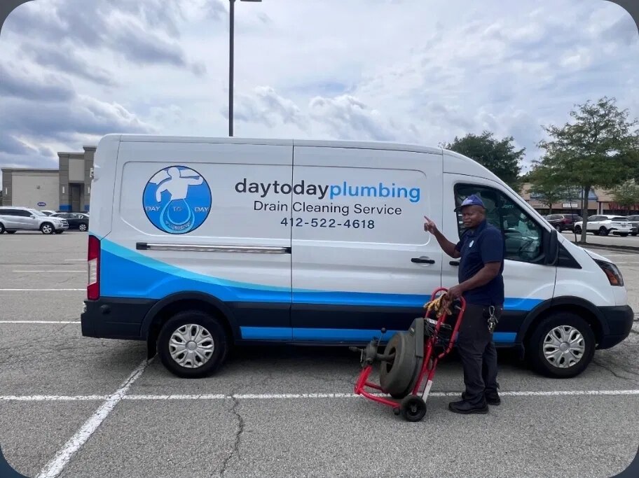 Fitzroy, owner of Day to Day Plumbing, standing next to the company van with a drain cleaning machine in Pittsburgh PA
