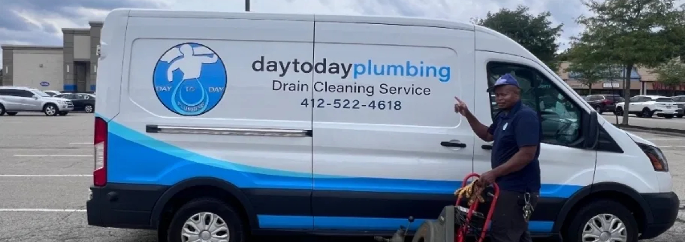 Fitzroy, owner of Day to Day Plumbing, standing next to the company van with a drain cleaning machine in Pittsburgh PA