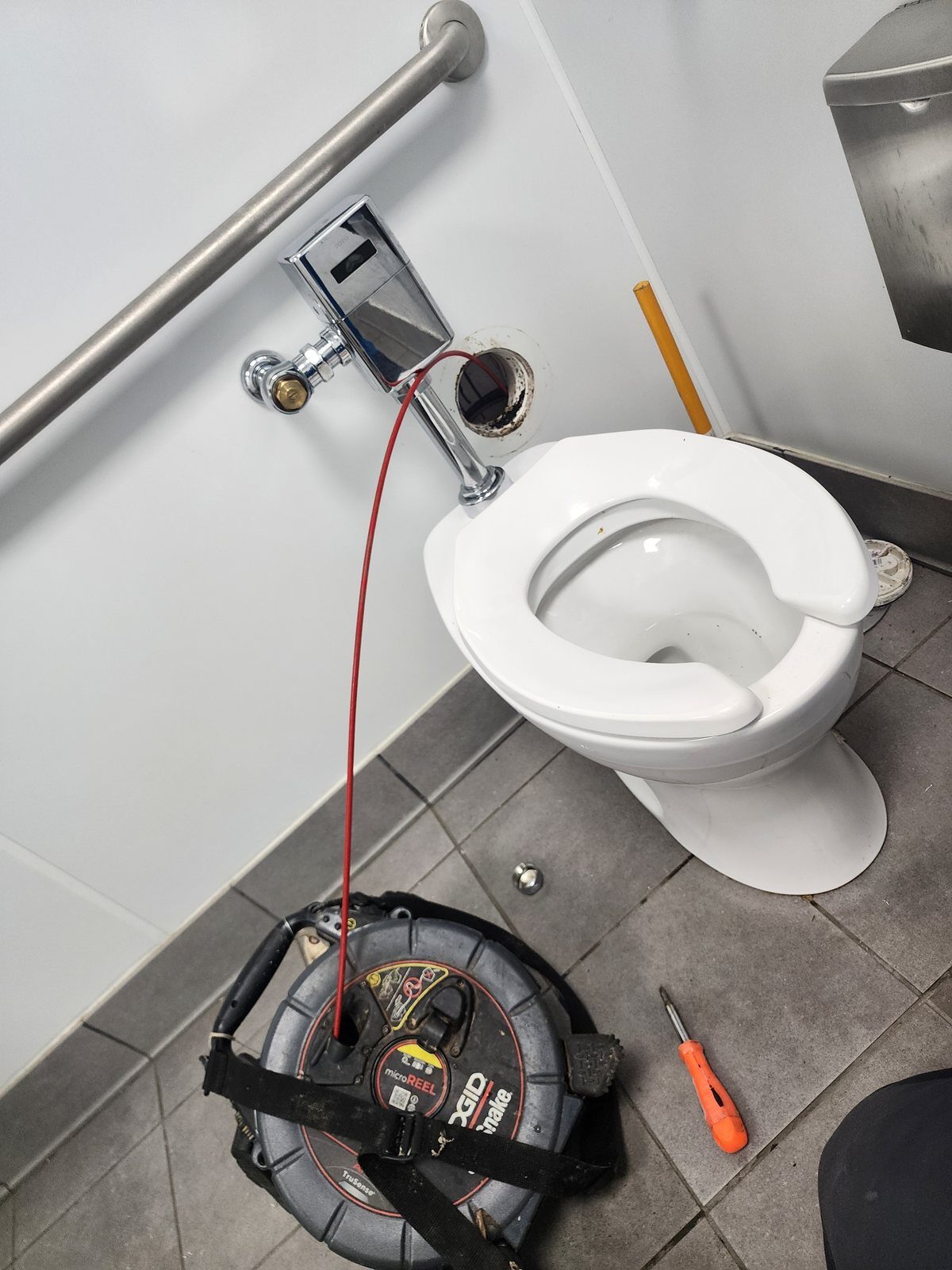 Cabling a blocked toilet waste line in a commercial restroom