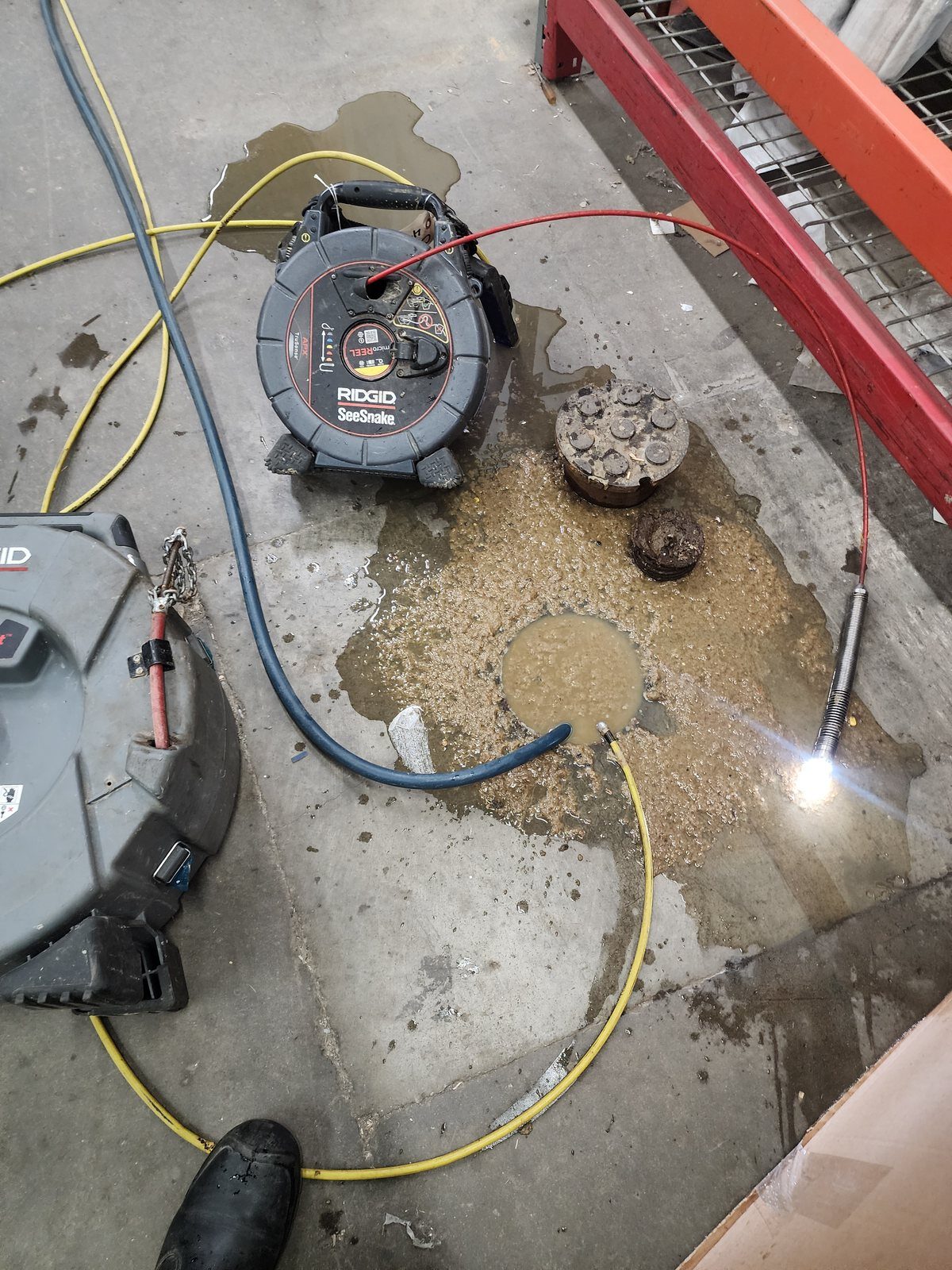 Sewer camera and drain cable at a commercial warehouse floor cleanout