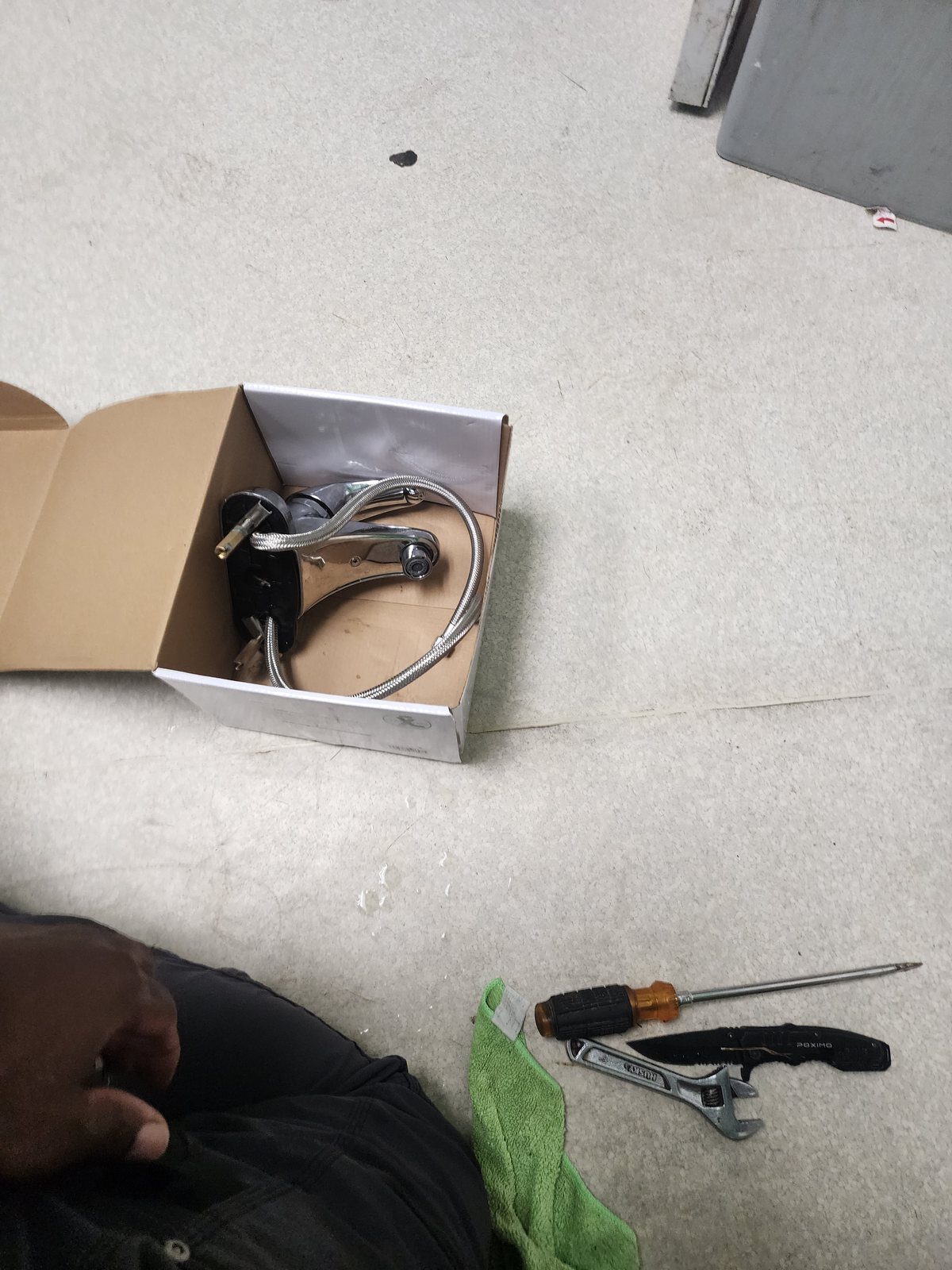 Commercial faucet unboxed on site with tools