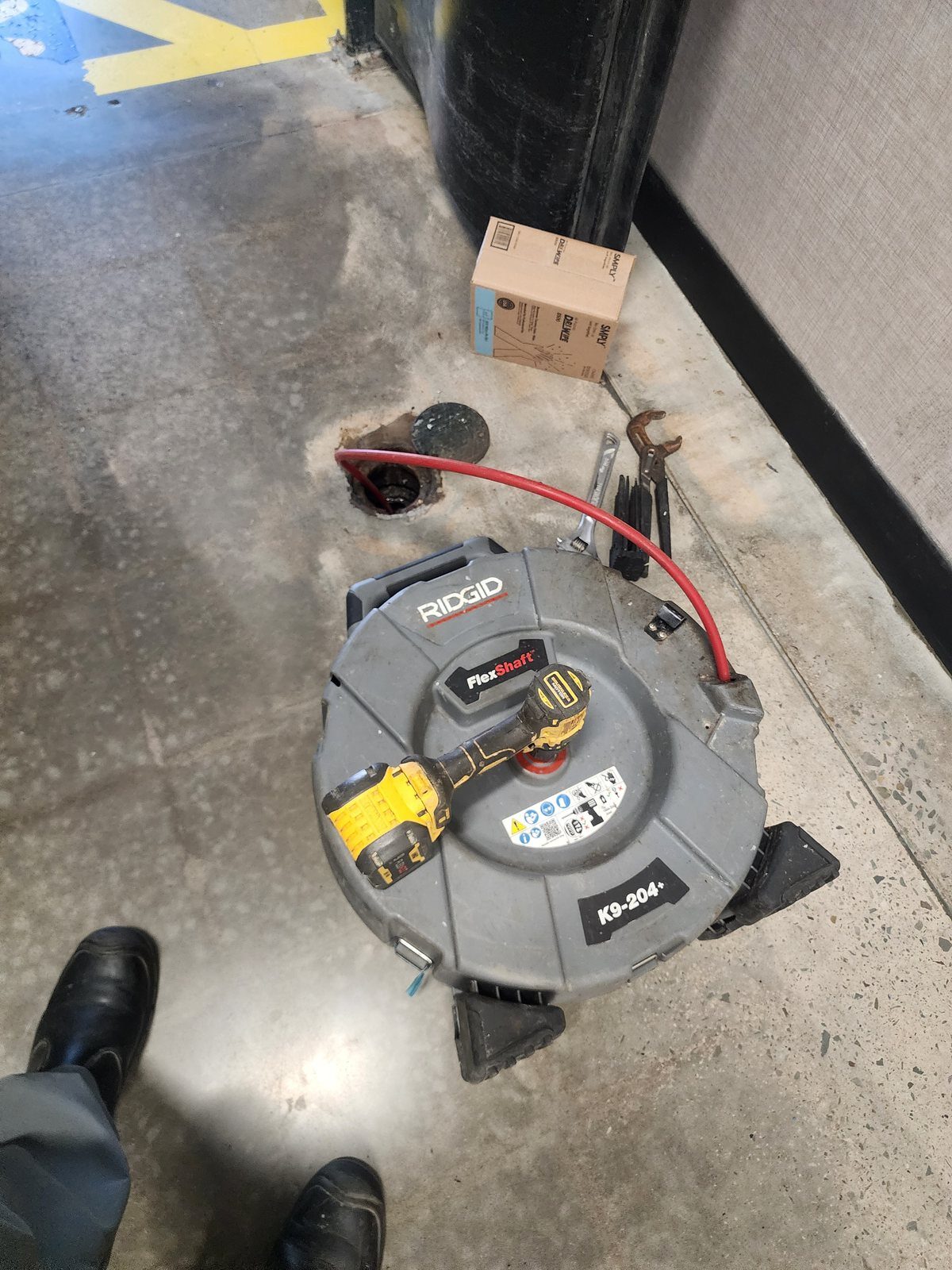 Drain cleaning machine set up at a floor cleanout on a commercial job