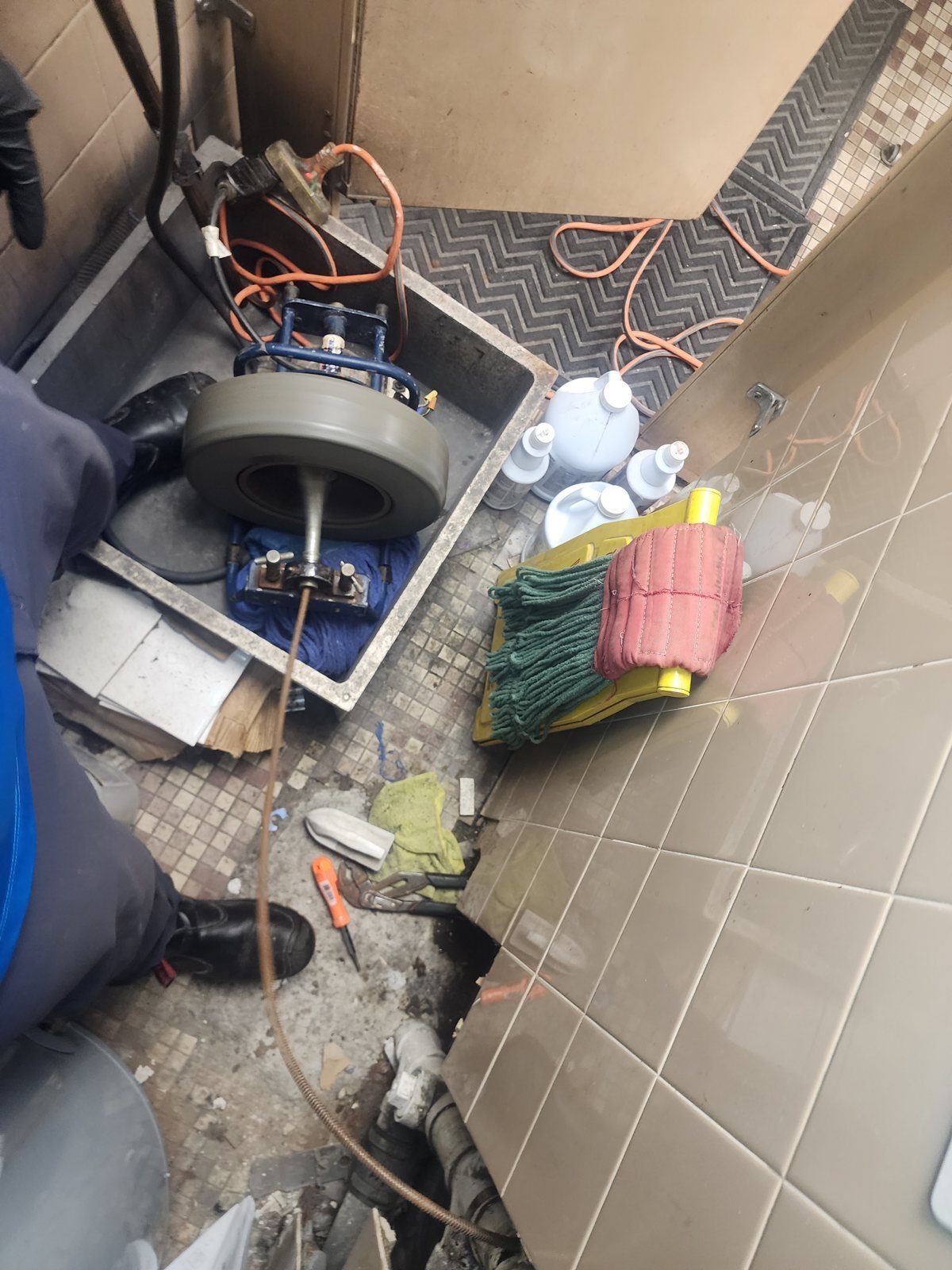 Sectional drum drain machine set up at a janitor closet mop sink