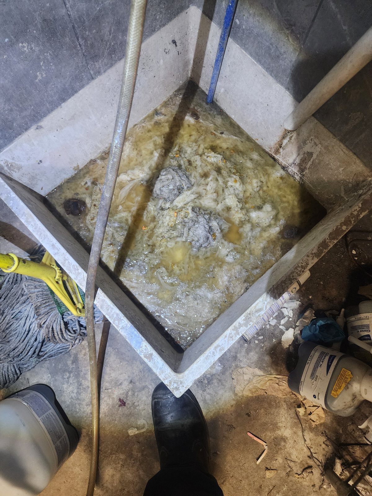 Commercial mop sink blocked solid with congealed grease and wipes