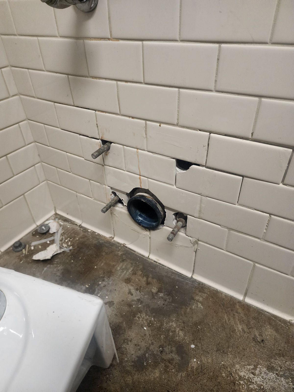 Wall-hung toilet removed exposing the carrier and closet flange