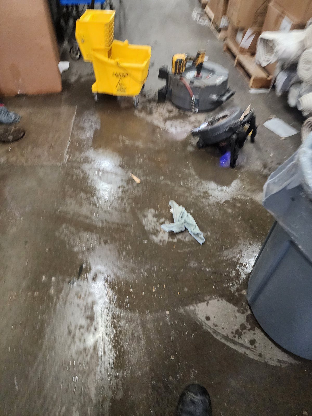 Water across a warehouse floor from a backed-up drain line